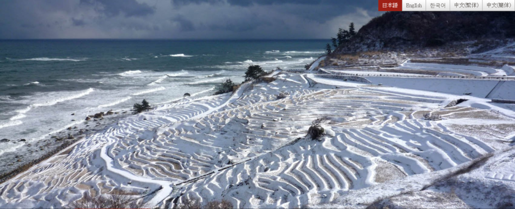 雪の白に覆われた棚田と日本海の荒波 - -石川県輪島市：白米千枚田- -